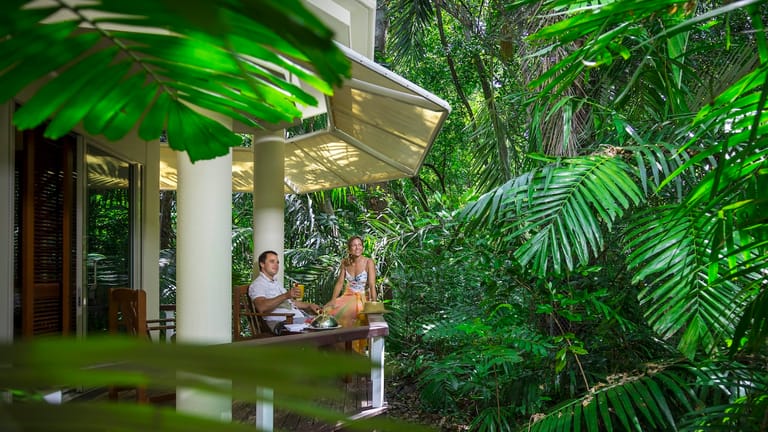 View of a couple on a Reef suite balcony as viewed from the trees.