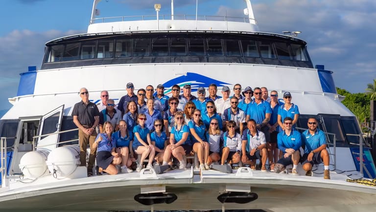 The Great Adventures crew gathering for a group short on the front hull of a vessel.